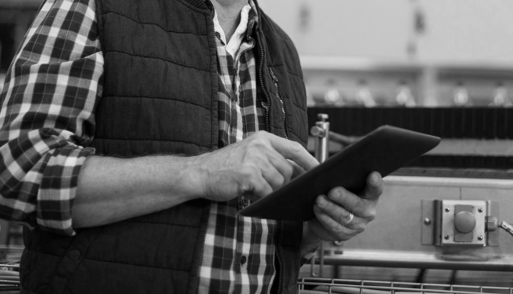 Smiling factory worker using digital tablet in the factory